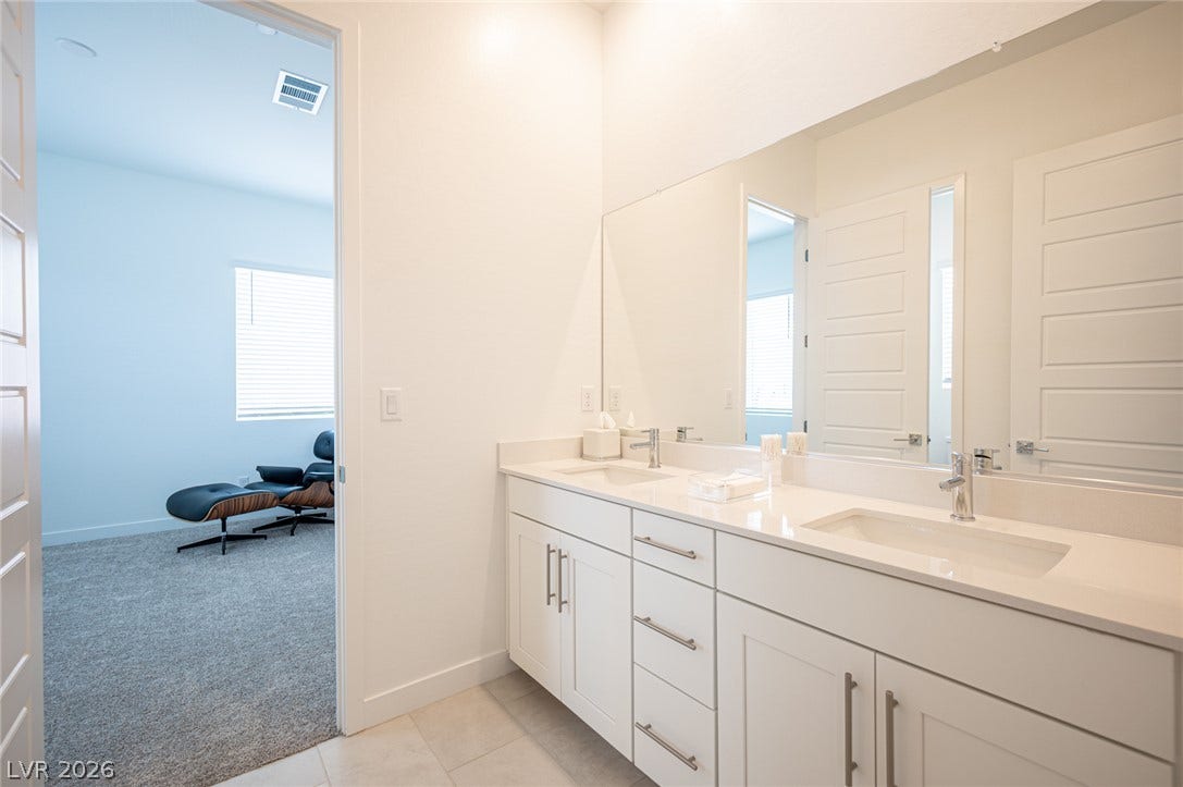 3904 Aiden Creek Avenue, North Las Vegas, NV 89031 A spacious double vanity features sleek solid surface countertops and modern cabinetry.