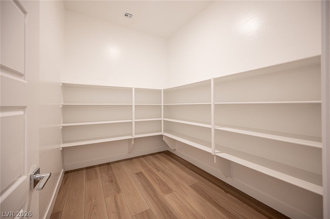 3904 Aiden Creek Avenue, North Las Vegas, NV 89031 Generous built-in shelving wraps around this walk-in storage space featuring warm wood flooring.