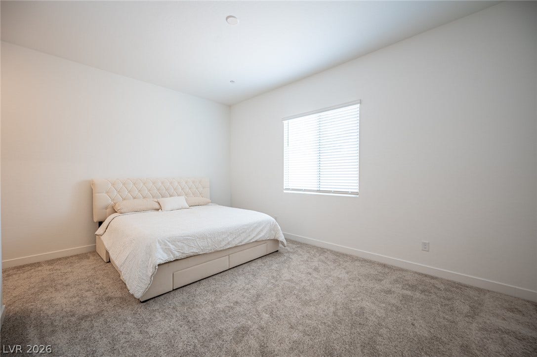 3904 Aiden Creek Avenue, North Las Vegas, NV 89031 Soft carpeting pairs with a large window to create a serene and inviting atmosphere.