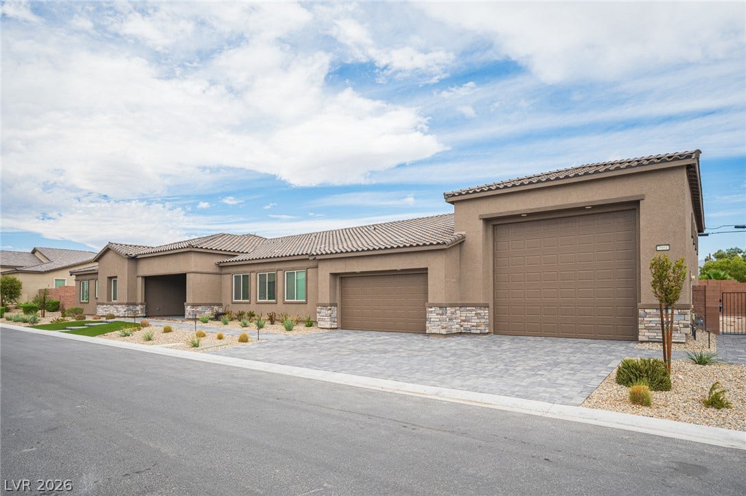 3904 Aiden Creek Avenue, North Las Vegas, NV 89031 A spacious driveway and multi-car garage bays anchor this modern desert elevation.