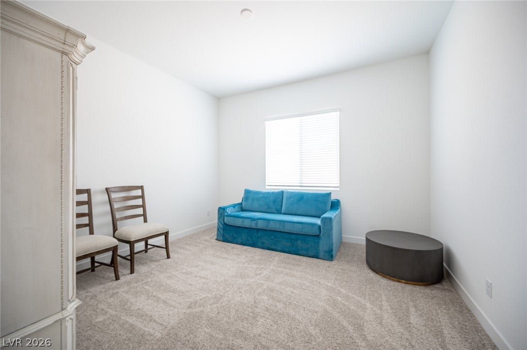 3904 Aiden Creek Avenue, North Las Vegas, NV 89031 Right of the primary you will find the cozy den with plush wall-to-wall carpeting and clean white walls which define this versatile bonus space.