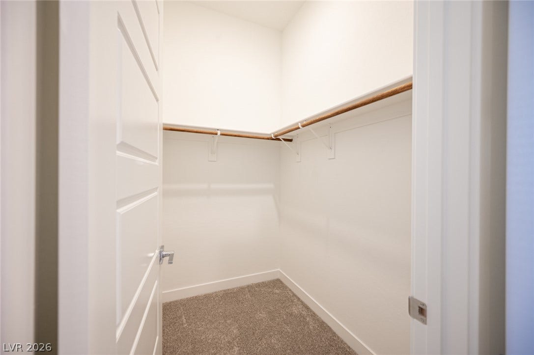 3904 Aiden Creek Avenue, North Las Vegas, NV 89031 Soft carpeting underfoot accents a neatly designed walk-in closet with built-in wooden hanging rods.