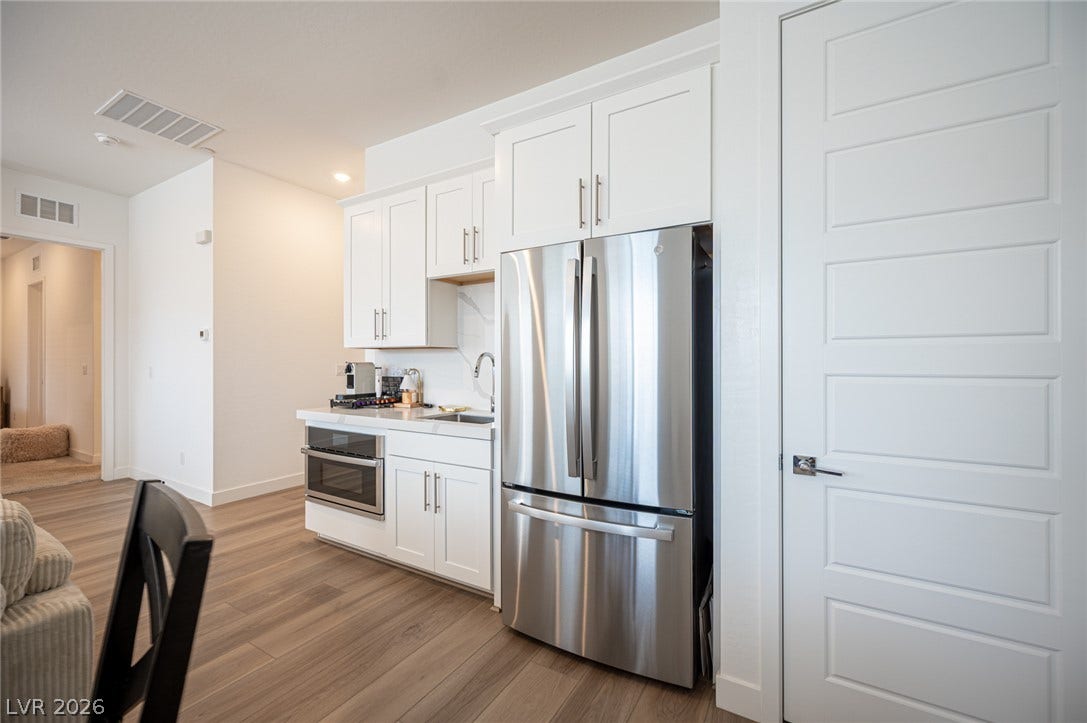 3904 Aiden Creek Avenue, North Las Vegas, NV 89031 Sleek stainless steel appliances integrate seamlessly into clean white cabinetry and modern wood-style flooring.