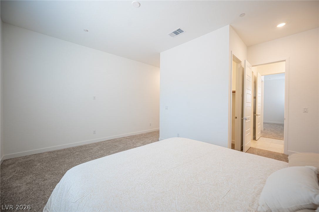 3904 Aiden Creek Avenue, North Las Vegas, NV 89031 Plush carpeting underfoot complements the pristine walls and recessed lighting of this modern bedroom.