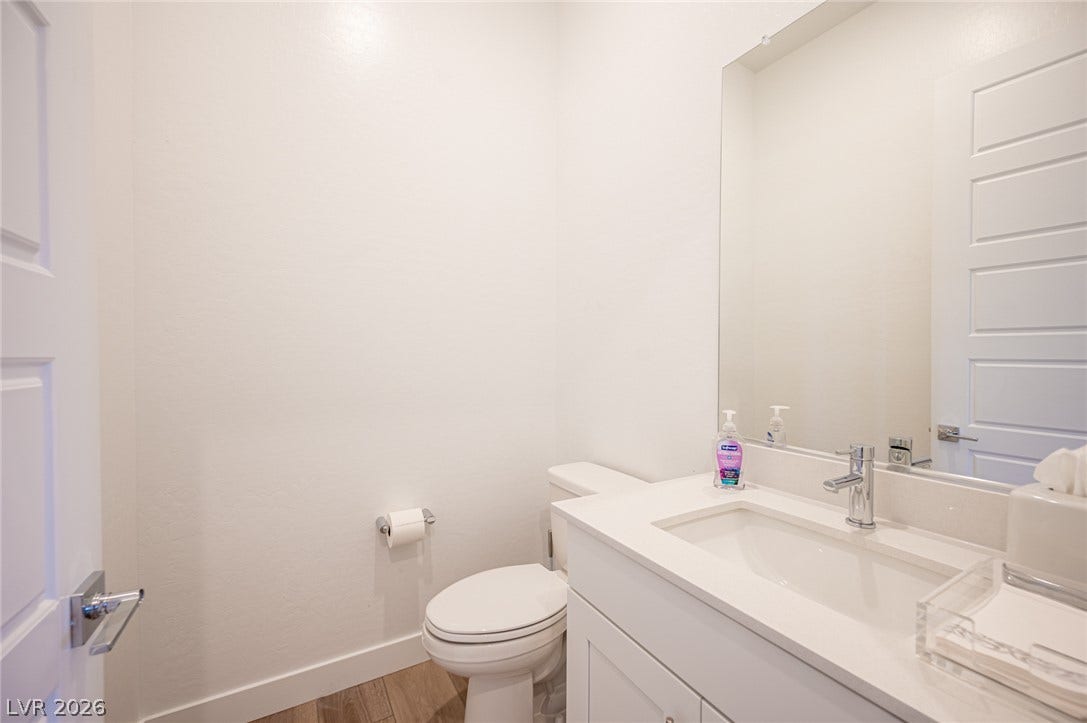 3904 Aiden Creek Avenue, North Las Vegas, NV 89031 A crisp white vanity with stone counters anchors this streamlined powder room.