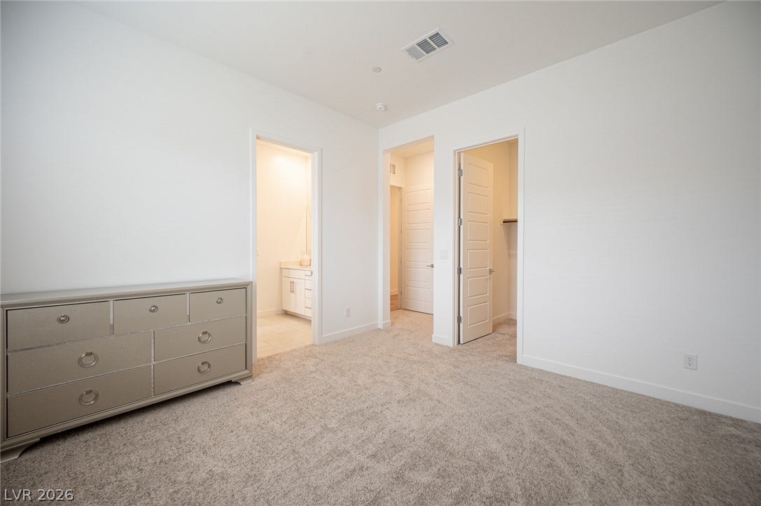 3904 Aiden Creek Avenue, North Las Vegas, NV 89031 Plush carpeting and soaring ceilings define this airy bedroom suite.