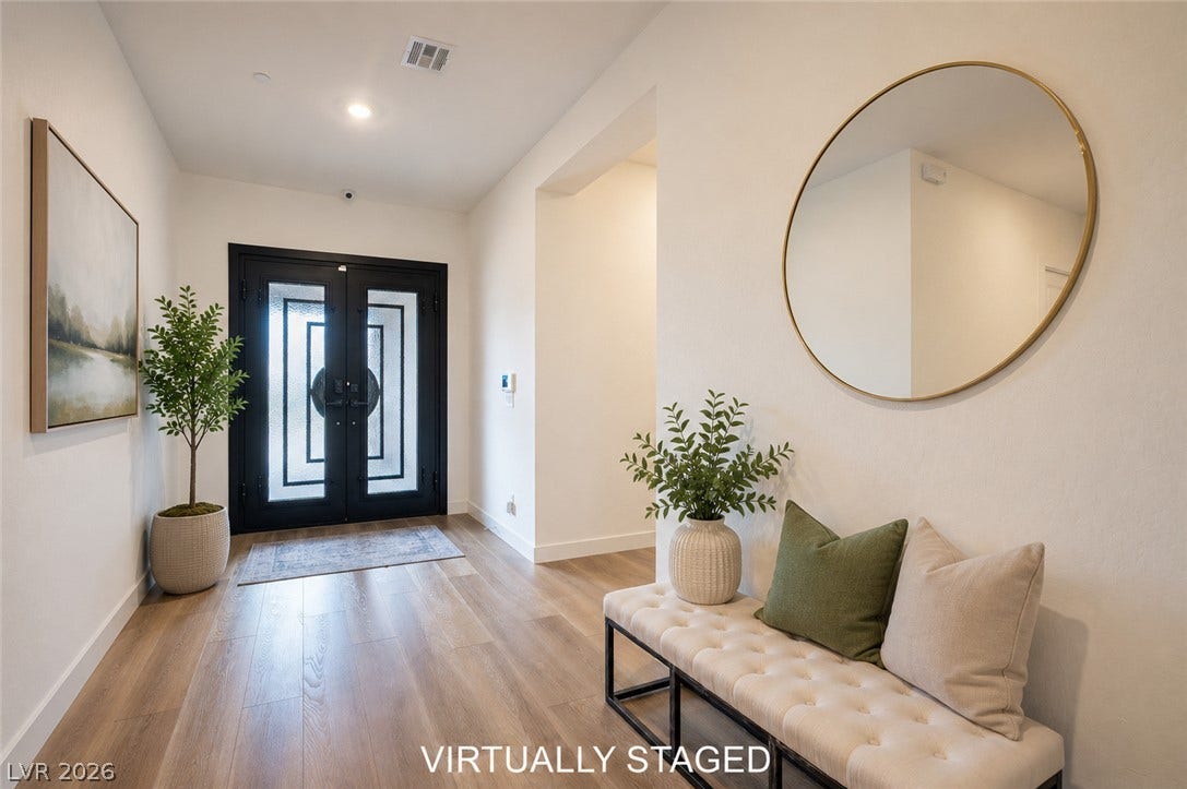 3904 Aiden Creek Avenue, North Las Vegas, NV 89031 Double front doors with geometric glass panes open into a wide hallway featuring wood-look flooring.