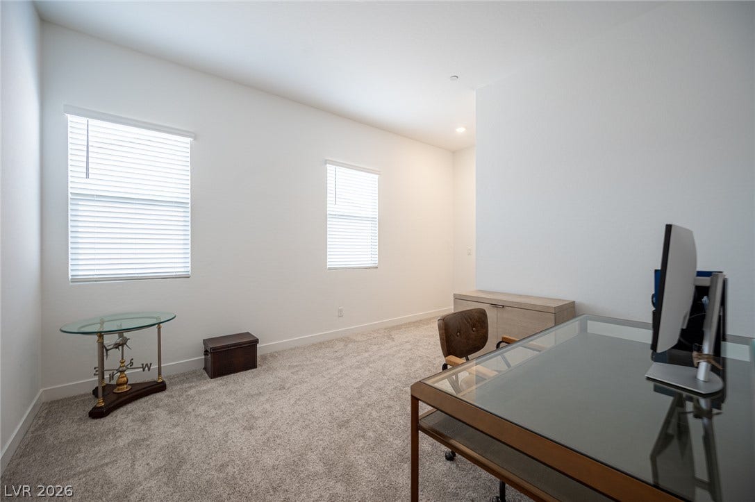 3904 Aiden Creek Avenue, North Las Vegas, NV 89031 Plush carpeting and dual windows illuminate this versatile home office workspace.