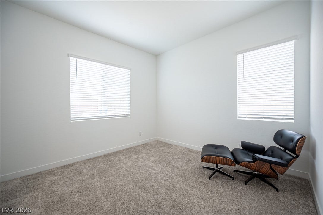 3904 Aiden Creek Avenue, North Las Vegas, NV 89031 Dual windows invite natural light across the soft carpeted floors of this versatile space.