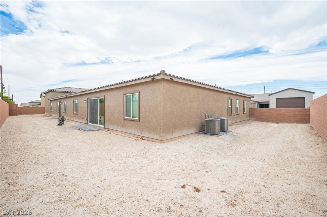 3904 Aiden Creek Avenue, North Las Vegas, NV 89031 An expansive gravel yard surrounds the exterior stucco walls of this modern desert residence.