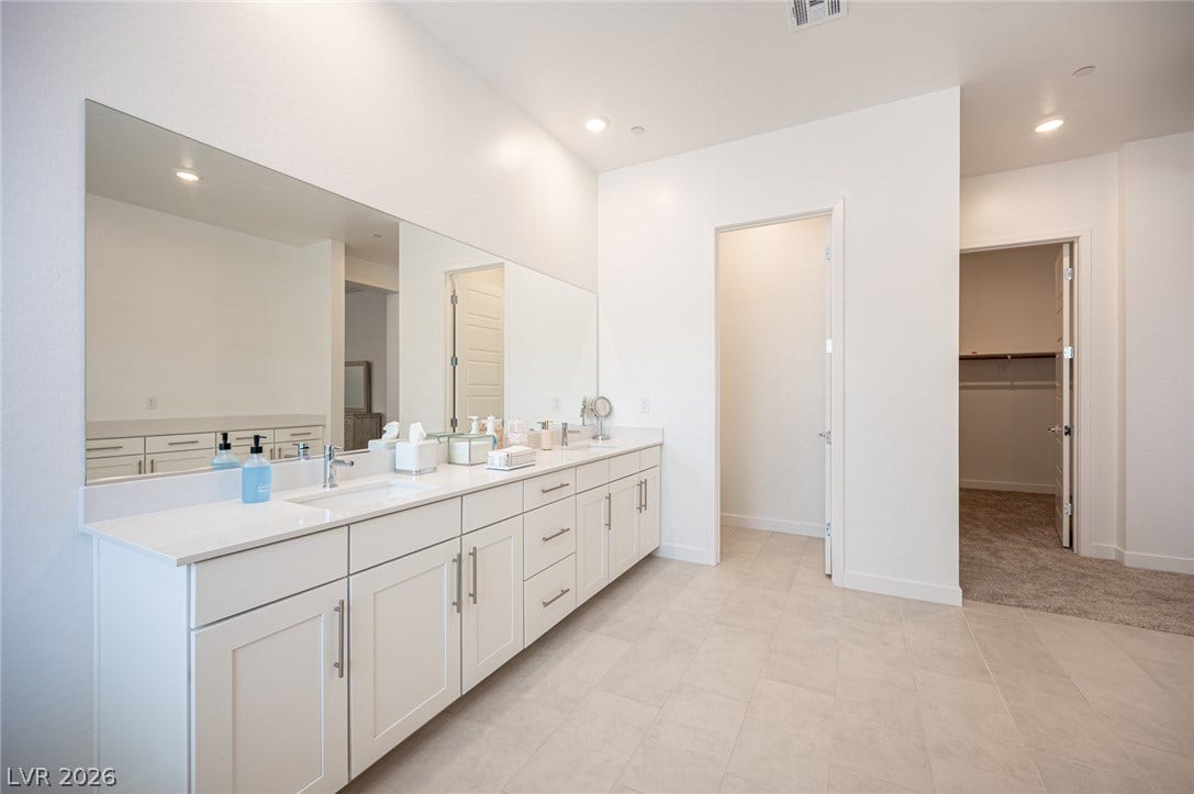 3904 Aiden Creek Avenue, North Las Vegas, NV 89031 A long double vanity with stone counters provides ample space in this modern bathroom.