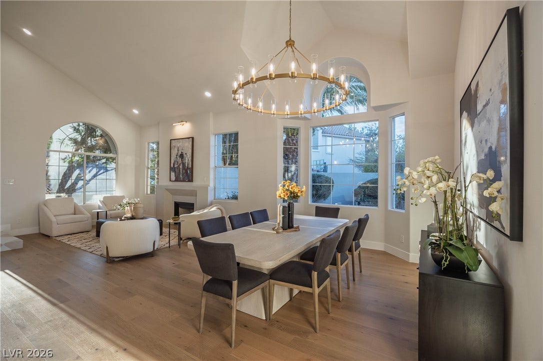 8800 Lusso Court, Las Vegas, NV 89134 Dining area featuring vaulted ceiling, wood-type flooring, a fireplace, and hanging lights