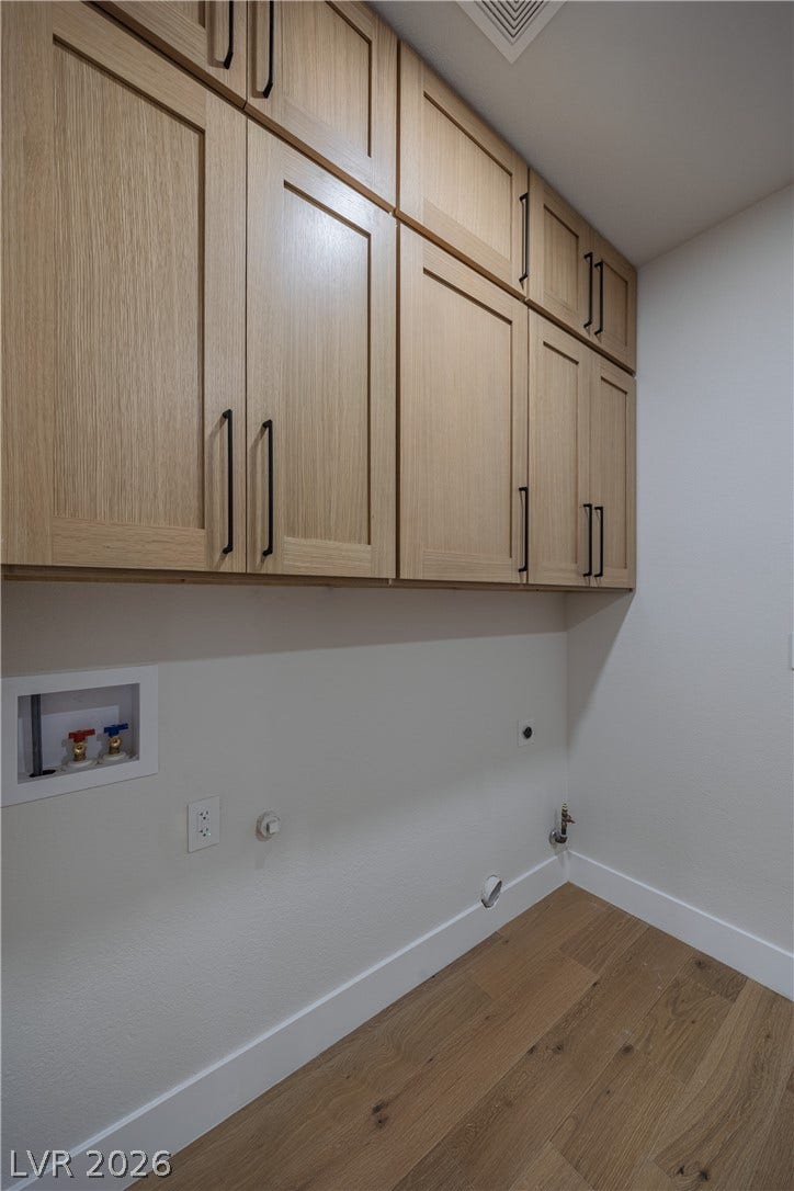 8800 Lusso Court, Las Vegas, NV 89134 Laundry room with gas dryer hookup, cabinet space, washer hookup, hardwood / wood-style floors, and electric dryer hookup
