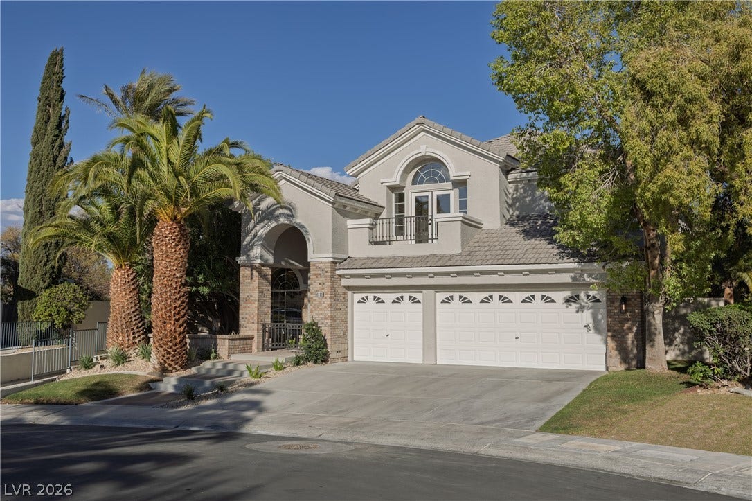 8800 Lusso Court, Las Vegas, NV 89134 View of front of property with stucco siding, french doors, driveway, and brick siding