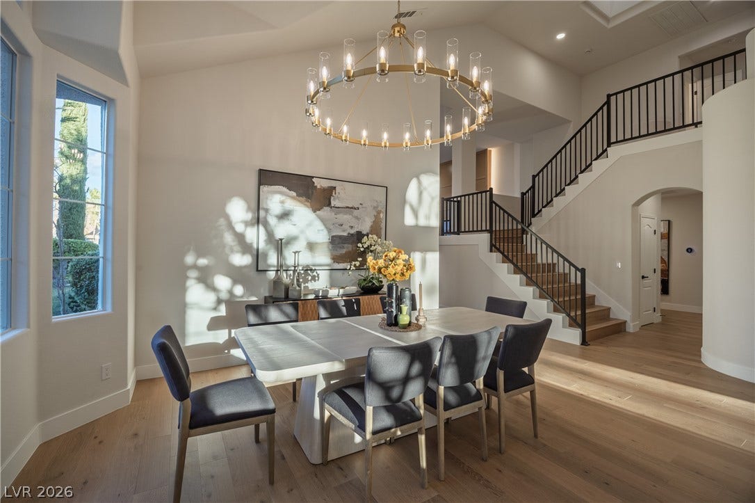 8800 Lusso Court, Las Vegas, NV 89134 Dining space featuring arched walkways, hardwood / wood-style floors, suspended lighting, and a high ceiling