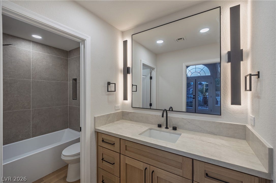 8800 Lusso Court, Las Vegas, NV 89134 Full bath with vanity, a textured wall, washtub / shower combination, recessed lighting, and light wood-type flooring