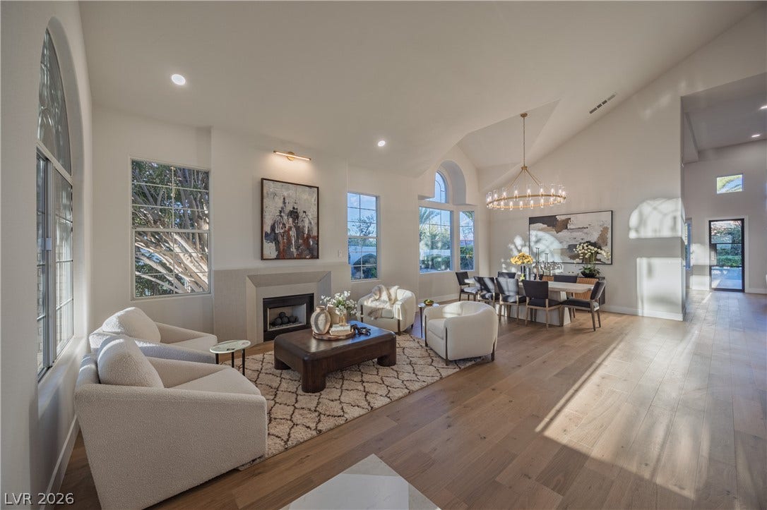 8800 Lusso Court, Las Vegas, NV 89134 Living room featuring hardwood / wood-style flooring, a fireplace, lofted ceiling, and a chandelier