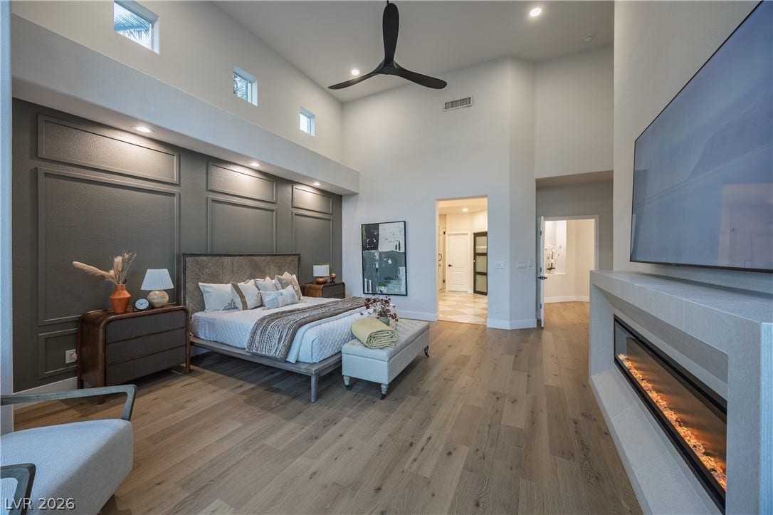 8800 Lusso Court, Las Vegas, NV 89134 Bedroom with a glass covered fireplace, recessed lighting, a high ceiling, light wood-style flooring, and ceiling fan