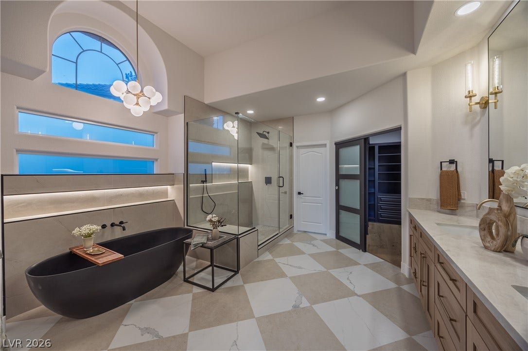 8800 Lusso Court, Las Vegas, NV 89134 Bathroom featuring a stall shower, a freestanding bath, vanity, hanging lights, and light flooring