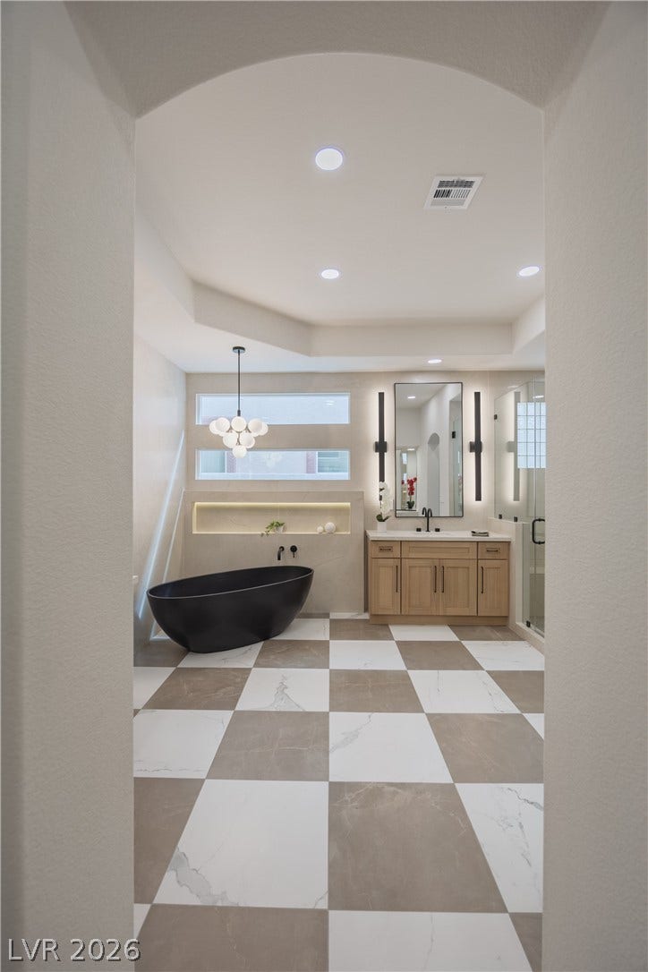 Full bathroom featuring vanity, a soaking tub, a stall shower, plenty of natural light, and recessed lighting