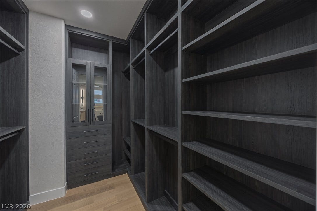 Walk in closet with light wood-style floors