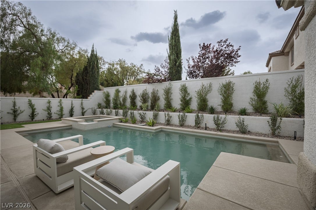 Integrated pool / hot tub with a fenced backyard and a patio area