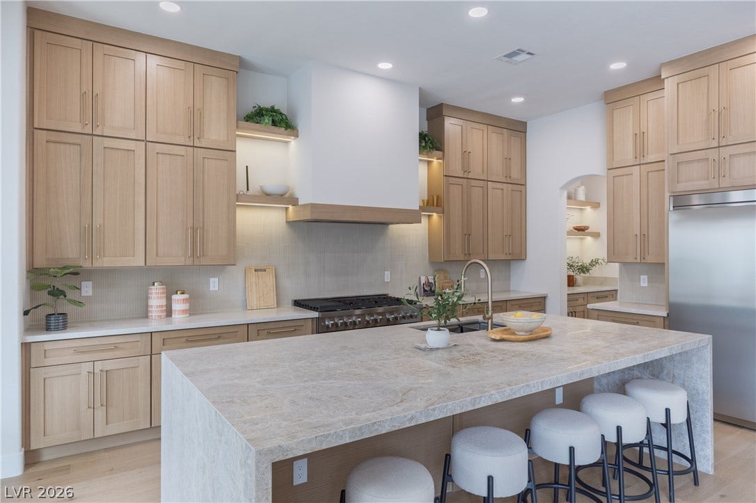 Kitchen featuring open shelves, light stone counters, stainless steel appliances, a kitchen bar, and light wood-type flooring