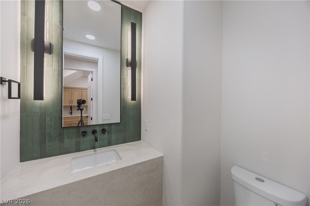 Half bathroom with backsplash and vanity