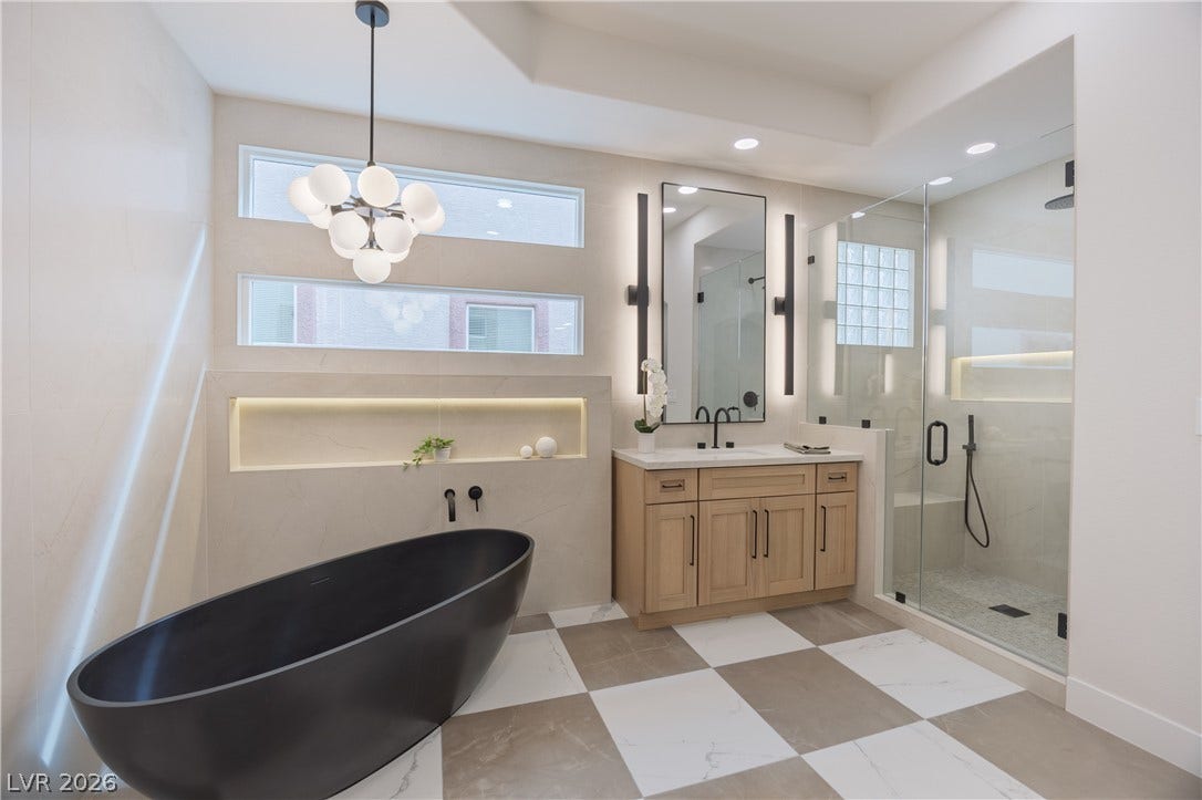 Full bath featuring vanity, a stall shower, a freestanding tub, light flooring, and suspended lighting