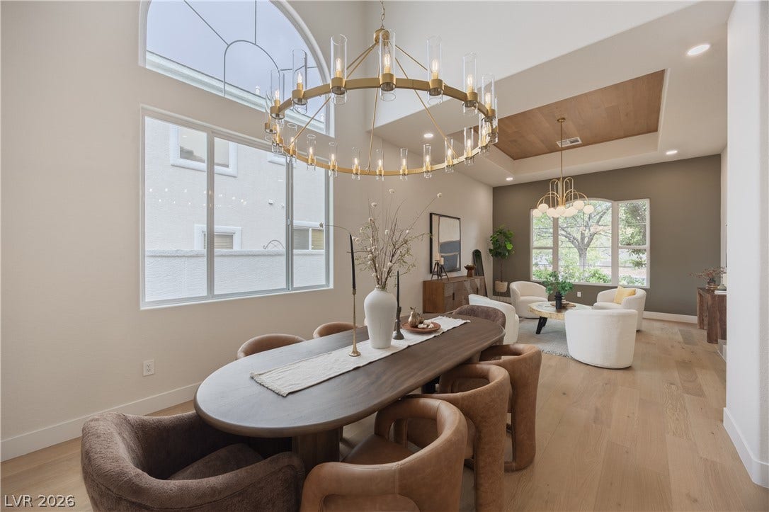 Dining space featuring light wood-style floors, suspended lighting, and a wooden tray ceiling