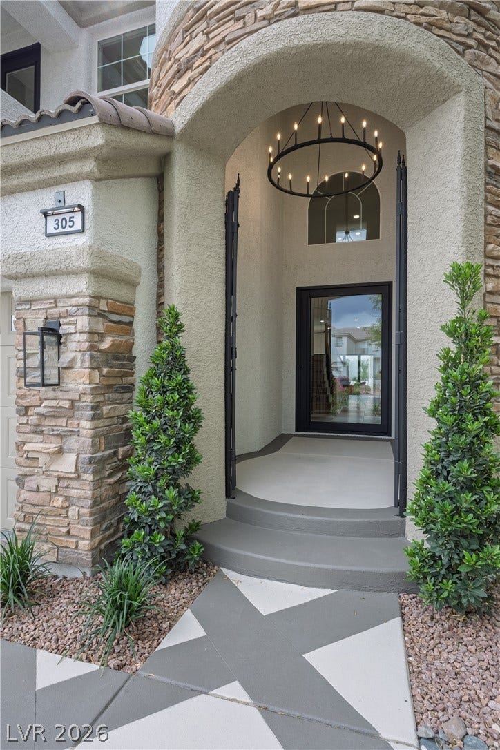 Entrance to property featuring stucco siding and stone siding
