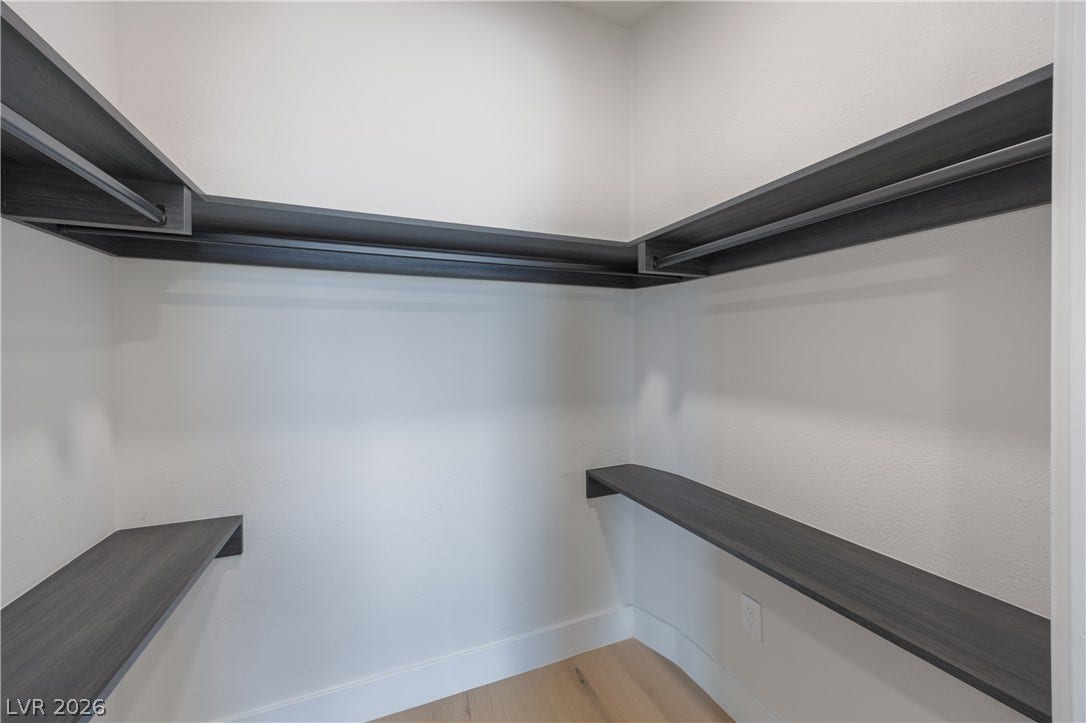 Walk in closet with light wood-style floors