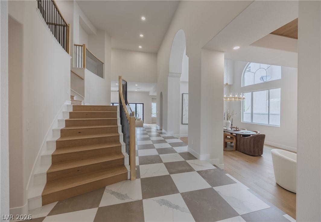 Foyer with a high ceiling, arched walkways, and recessed lighting