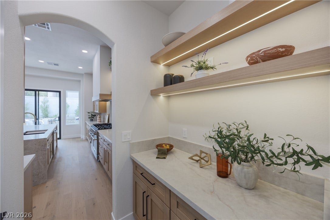 Bar with open shelves, light stone counters, light wood-style floors, stainless steel stove, and recessed lighting