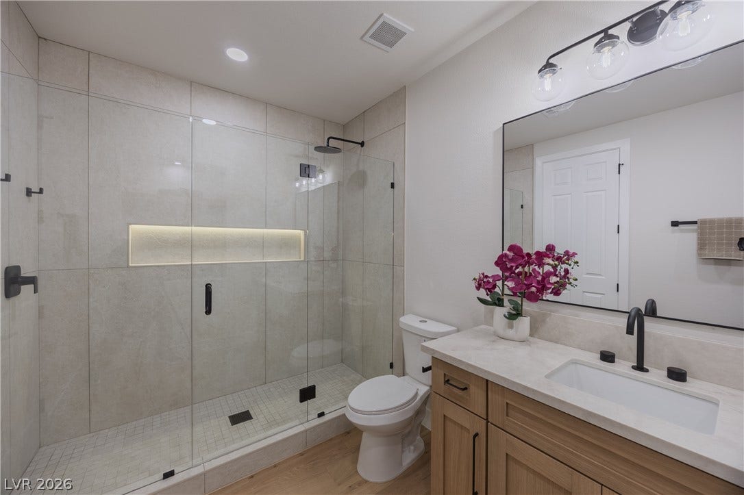 Bathroom with vanity, a stall shower, and light wood-style floors