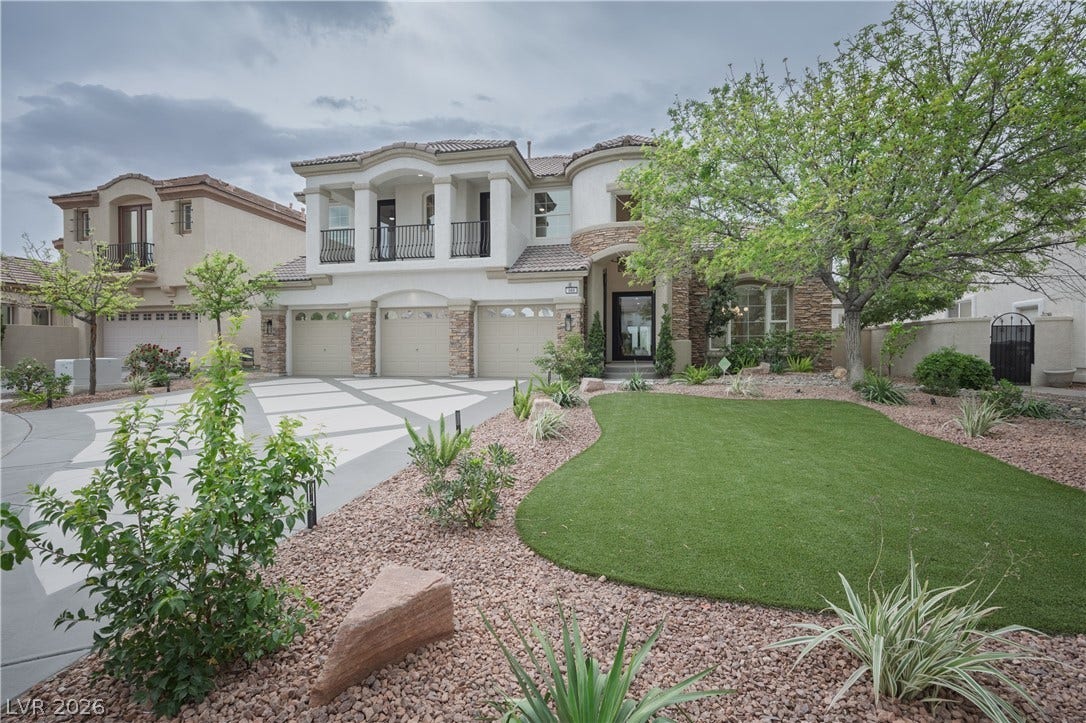 Mediterranean / spanish-style home with an attached garage, driveway, stucco siding, a balcony, and a tiled roof