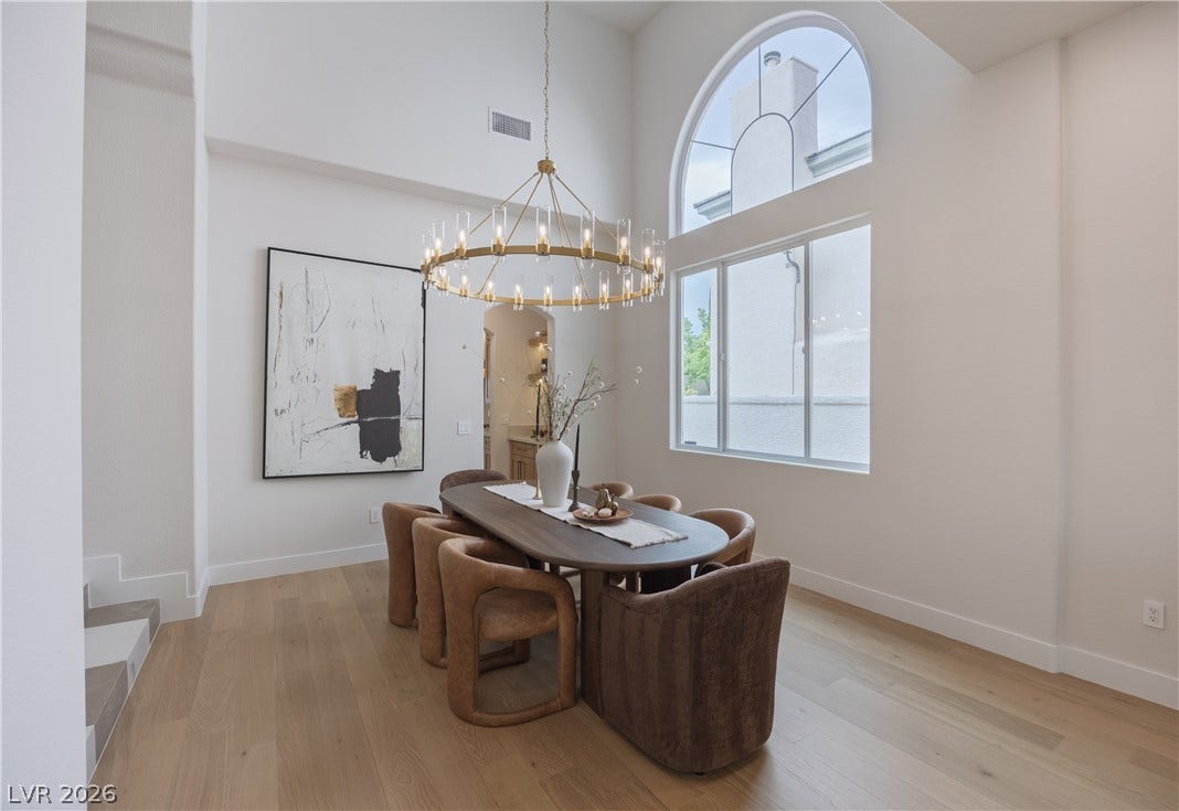 Dining area featuring light wood-style floors, a high ceiling, and hanging lights