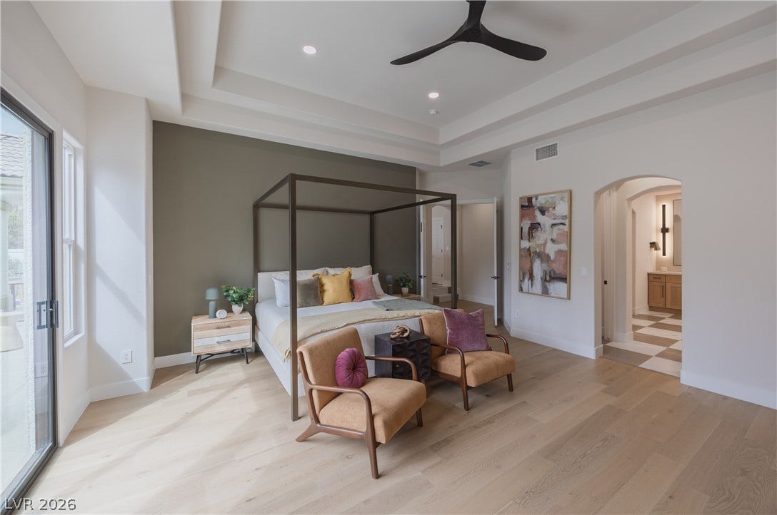 Bedroom with arched walkways, ensuite bathroom, recessed lighting, light wood finished floors, and a ceiling fan