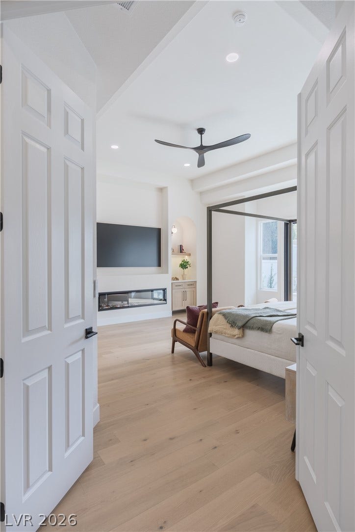 Bedroom with recessed lighting, light wood-style flooring, a ceiling fan, and ensuite bath