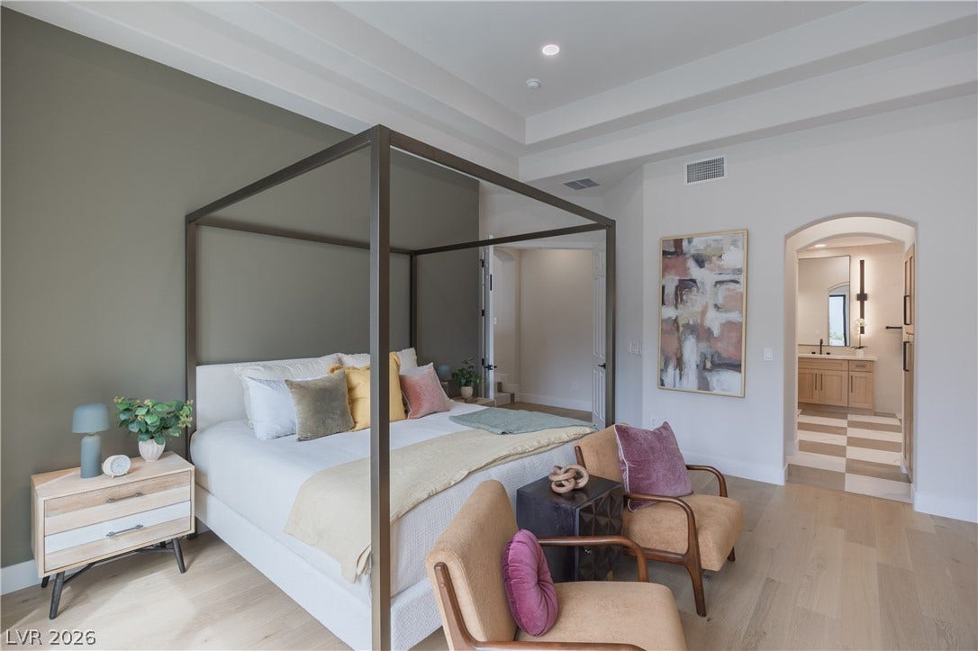 Bedroom with arched walkways, light wood-style flooring, connected bathroom, and recessed lighting