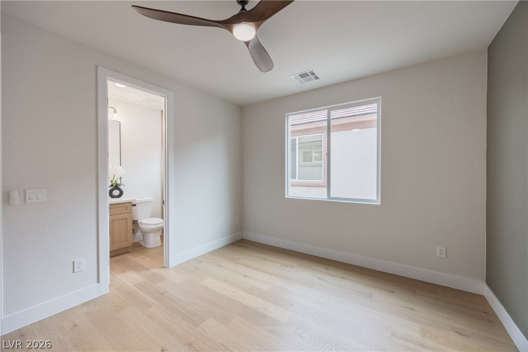 Unfurnished bedroom featuring light wood-style floors, connected bathroom, and a ceiling fan