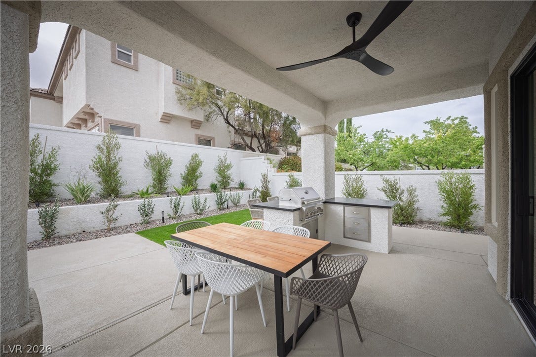 Fenced backyard featuring an outdoor kitchen / dining area, ceiling fan, and a patio area
