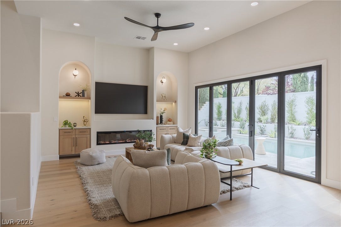 Living area featuring built in shelves, ceiling fan, light wood finished floors, recessed lighting, and a glass covered fireplace