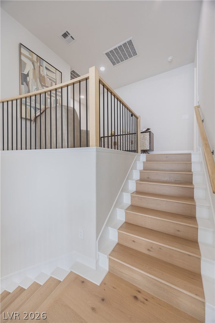 Stairs featuring wood-type flooring and recessed lighting