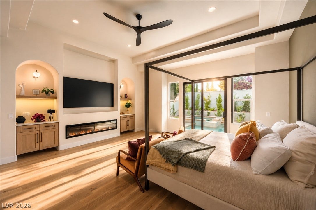 Hardwood floors and a sleek fireplace complement the bedroom's private patio access.
