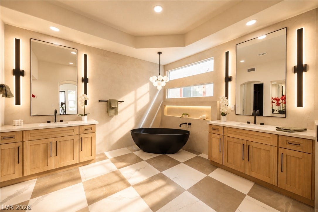 Indulge in a luxurious primary bathroom, boasting a sleek freestanding tub and dual vanities with expansive mirrors.