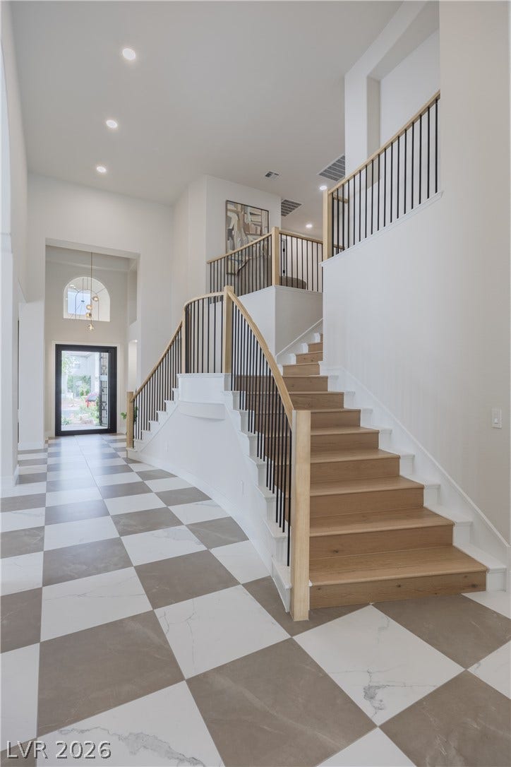 Entrance foyer with a high ceiling and recessed lighting