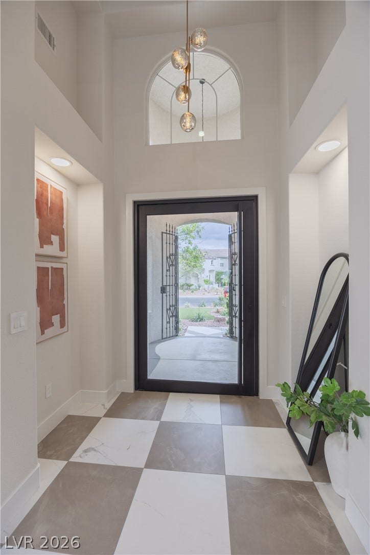 Entryway with a high ceiling and baseboards