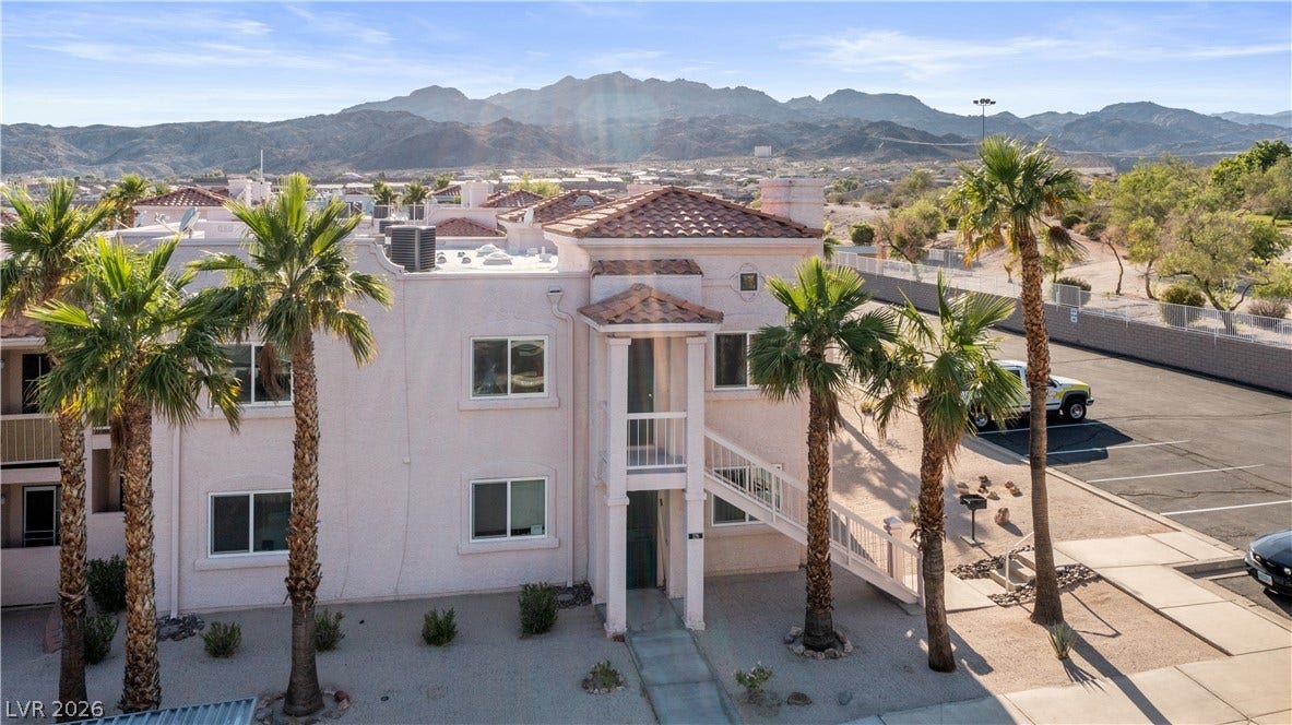 View of building exterior with a mountain view and uncovered parking