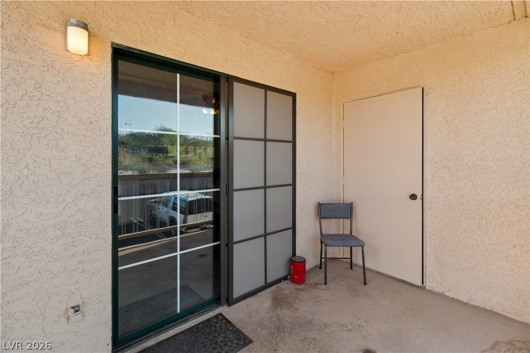 Doorway to property featuring stucco siding